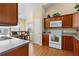 Well-lit kitchen featuring laminate floors, white appliances, and wood cabinets at 2186 Quinn Ln, The Villages, FL 32162