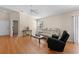 Comfortable living room area with a neutral sofa, a black recliner, hardwood floors, and natural lighting at 2186 Quinn Ln, The Villages, FL 32162