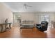 A living room featuring a plush beige sofa, a leather recliner, and a glass coffee table on hardwood floors at 2186 Quinn Ln, The Villages, FL 32162