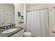 Bright bathroom featuring granite counters and a white textured shower curtain at 2897 Sunridge Loop, St Cloud, FL 34771