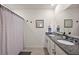 Bathroom featuring dual sinks, granite countertops, and a decorative mirror at 2897 Sunridge Loop, St Cloud, FL 34771