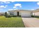 Well-manicured front lawn leading to a two-car garage and cozy facade at 2897 Sunridge Loop, St Cloud, FL 34771