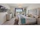 Main bedroom with decorative headboard, chandelier, and a sunlit window at 2897 Sunridge Loop, St Cloud, FL 34771