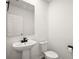 Modern powder room with a pedestal sink, sleek black fixtures, and a crisp, clean aesthetic at 29447 Caspian St, Leesburg, FL 34748