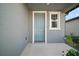 A welcoming blue front door with white trim and an adjacent window at 29447 Caspian St, Leesburg, FL 34748