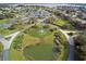 Aerial view of a community featuring a large pond, lush landscaping, parking, and a community center at 2982 Lake Huron Ln, Tavares, FL 32778