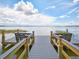 Water view from the end of a dock, with blue skies, white clouds, and seating for peaceful relaxation at 2982 Lake Huron Ln, Tavares, FL 32778