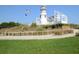 Scenic lighthouse view with walkway, white railings, a flagpole, and beautiful landscaping details at 2982 Lake Huron Ln, Tavares, FL 32778