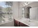 Bathroom with double sinks, white walls, white cabinets, and a window providing natural light at 34448 Tuscany Ave, Sorrento, FL 32776