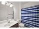 Bathroom features a white sink and toilet, and a blue striped shower curtain at 34448 Tuscany Ave, Sorrento, FL 32776