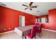 Dining room with red walls, ceiling fan, with tan floors, and red chairs at 34448 Tuscany Ave, Sorrento, FL 32776