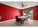 A dining room with red walls, a ceiling fan, and a sliding glass door leading to the outdoors at 34448 Tuscany Ave, Sorrento, FL 32776