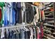 A walk-in closet with clothes neatly arranged on hangers and shelves with shoes stacked neatly at 34448 Tuscany Ave, Sorrento, FL 32776