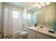 Well-lit bathroom featuring tiled walls, a shower-tub combo, and a vanity with ample counter space at 3603 Eversholt St, Clermont, FL 34711