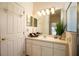 Bright bathroom featuring a vanity with white cabinets and a framed mirror with decorative lighting at 3603 Eversholt St, Clermont, FL 34711