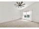 Light-filled bedroom with high ceiling, ceiling fan, carpet floors, and large window at 3603 Eversholt St, Clermont, FL 34711