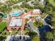 Aerial view of clubhouse with manicured landscaping, pool, parking, and roundabout entrance at 3603 Eversholt St, Clermont, FL 34711