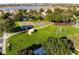 Aerial view of a park with tennis and basketball courts surrounded by mature trees and lush green grass at 3603 Eversholt St, Clermont, FL 34711