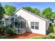 Back exterior featuring screened in patio with mature landscaping and lawn at 3603 Eversholt St, Clermont, FL 34711