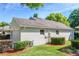 Exterior view of a house with a two-car garage, showing lawn and mulched garden at 3603 Eversholt St, Clermont, FL 34711