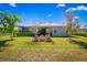 Serene backyard featuring lush landscaping, mature trees, and a screened lanai, ideal for outdoor living at 3666 Arlington Ridge Blvd, Leesburg, FL 34748