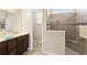 Modern bathroom featuring a dark vanity, tiled shower with glass partition, and a separate toilet area at 3666 Arlington Ridge Blvd, Leesburg, FL 34748