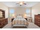 This bedroom features a ceiling fan, two windows, and a traditional furniture set for a cozy feel at 3666 Arlington Ridge Blvd, Leesburg, FL 34748