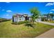 Beautifully landscaped front yard of a well-maintained home with lush greenery and a long driveway at 3666 Arlington Ridge Blvd, Leesburg, FL 34748