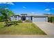 Charming single-story home featuring a well-manicured lawn, lush landscaping, and a two-car garage at 3666 Arlington Ridge Blvd, Leesburg, FL 34748