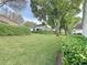 Beautiful backyard featuring a well-manicured lawn, mature trees, and trimmed hedges at 3827 Westerham Dr, Clermont, FL 34711