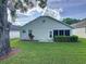 Grassy backyard with a screened in porch and mature landscaping at 3827 Westerham Dr, Clermont, FL 34711