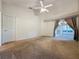 Carpeted bedroom featuring neutral decor, ceiling fan, and access to a screened-in porch at 3827 Westerham Dr, Clermont, FL 34711