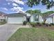 Well-maintained one-story home with a two-car garage and mature landscaping at 3827 Westerham Dr, Clermont, FL 34711