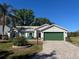 Charming single-story home with a well-manicured lawn, a brick driveway, and an attached two-car garage at 4344 River Ridge Dr, Leesburg, FL 34748