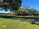 Scenic view of the golf course featuring mature trees, a paved cart path, and lush green grass at 4344 River Ridge Dr, Leesburg, FL 34748