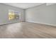 A well-lit bedroom with gray laminate flooring and a large window offering natural light at 4703 Golden Beach Ct, Kissimmee, FL 34746