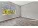 Bright bedroom featuring wood-look flooring and natural light from a large window at 4703 Golden Beach Ct, Kissimmee, FL 34746