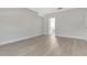 Light-filled bedroom with laminate floors, neutral walls, and an attached bathroom visible through the doorway at 4703 Golden Beach Ct, Kissimmee, FL 34746