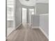 Hallway with laminate flooring, leading to open doorways, and light gray walls at 4703 Golden Beach Ct, Kissimmee, FL 34746