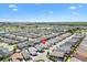 Scenic aerial view of a planned residential neighborhood with a community pond and green landscape at 5829 Tupelo Ter, The Villages, FL 32163