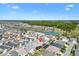 Neighborhood aerial view of a residential area with a lake and forest in the distance at 5829 Tupelo Ter, The Villages, FL 32163