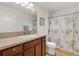 Well-lit bathroom with single sink, vanity, toilet, and a shower/tub combo with a decorative shower curtain at 5829 Tupelo Ter, The Villages, FL 32163