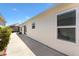 Exterior view of the home with sliding glass doors to a patio, and tidy landscaping at 5829 Tupelo Ter, The Villages, FL 32163