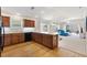 A modern open-concept kitchen features wood floors, cabinets, a breakfast bar, and a view of the living area at 5829 Tupelo Ter, The Villages, FL 32163