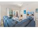Open living room with vaulted ceilings, a modern ceiling fan, and sliding glass doors to the screened-in lanai at 5829 Tupelo Ter, The Villages, FL 32163