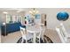 A cozy living room with a view of a dining area, a blue sofa, and backyard access through sliding glass doors at 5829 Tupelo Ter, The Villages, FL 32163