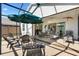 Spacious screened lanai has ample seating and a shady umbrella with access to the home's interior at 5829 Tupelo Ter, The Villages, FL 32163