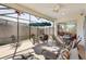 Relaxing screened-in patio with lots of seating, an umbrella, and overhead lighting at 5829 Tupelo Ter, The Villages, FL 32163