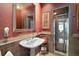 Classic bathroom with a pedestal sink, decorative mirror, and a glass-enclosed shower at 590 Sandlake Ct, Mount Dora, FL 32757