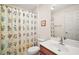 Bathroom features a vanity, a large mirror, and a shower with floral curtains at 604 Juanita Ct, The Villages, FL 32159